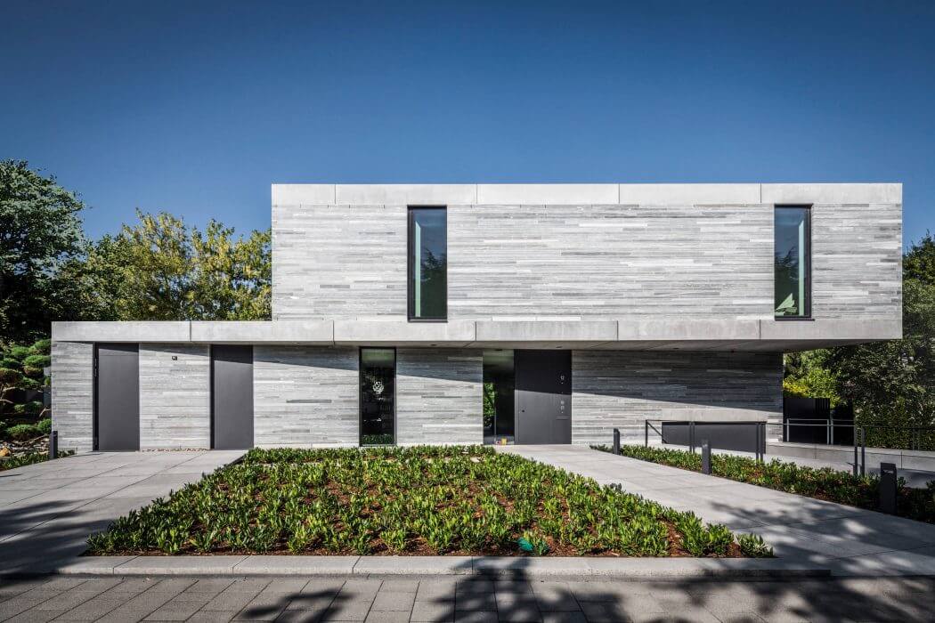 A modern, minimalist building with a striking concrete facade, clean lines, and minimal landscaping.