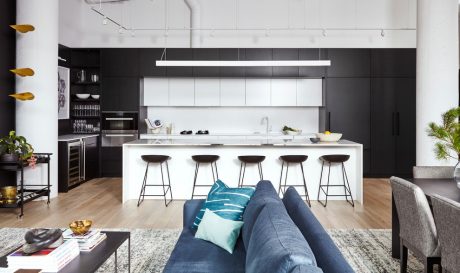 Sleek, modern kitchen with black cabinetry, white island, and floating wood shelves.