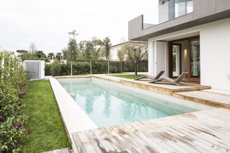 Sleek modern home surrounded by lush greenery and an inviting infinity pool.
