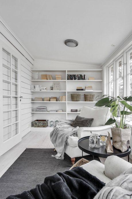 Cozy living space with built-in bookshelves, plush seating, and natural light accents.