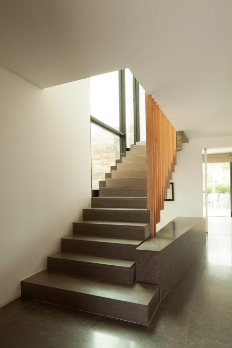 Sleek, modern staircase with clean lines, wood accents, and striking natural lighting.