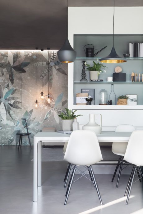 Minimalist dining area with abstract wall decor, floating shelves, and contemporary furnishings.