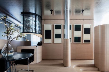 Modern minimalist interior featuring glass, metal, and neutral tones; clean lines and geometric shapes.