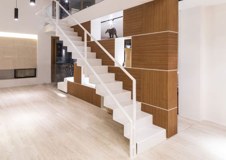 Sleek, modern staircase with wood paneling and storage units blending seamlessly.