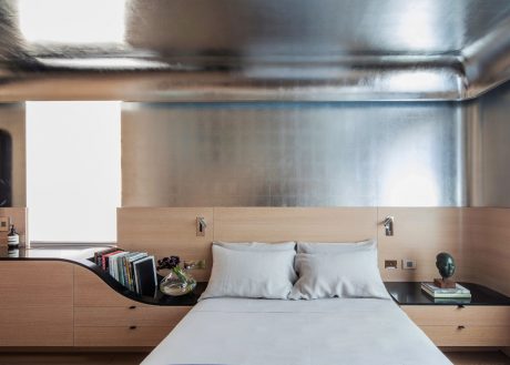 Sleek, minimalist bedroom with modern wood furnishings, metal accents, and hidden storage.