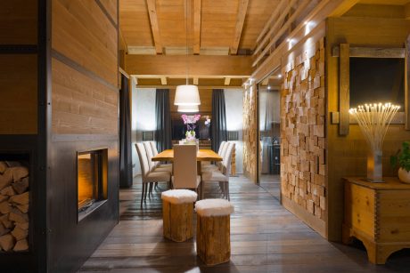 Cozy wooden interior with a fireplace, elegant dining area, and rustic accents.