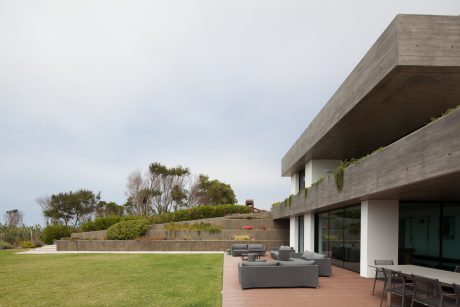 Sleek, modern architecture with concrete walls, a tiered outdoor space, and comfortable patio furniture.
