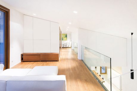 Minimalist interior with clean lines, wood tones, and glass railings complement the open layout.