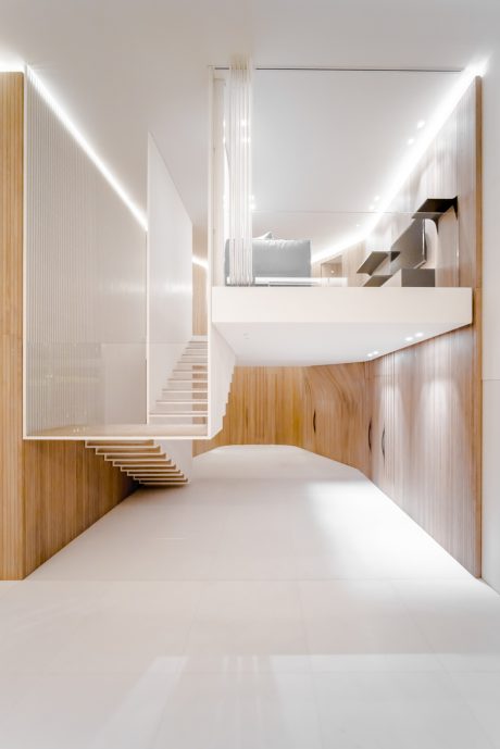 An elegant, minimalist interior with clean lines, warm wood accents, and sculptural staircase.