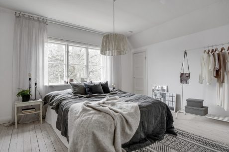 A cozy and well-designed bedroom with a prominent pendant light and ample storage space.