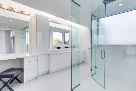 Sleek, modern bathroom with vanity, large mirrors, and walk-in glass shower.