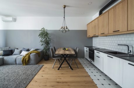 Spacious open-plan kitchen and living room with wooden furniture, tile floors, and modern lighting.