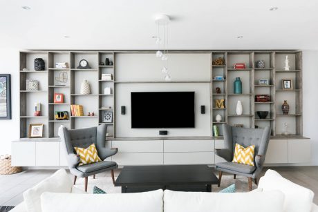Sleek, modern living room with customized shelving, TV, and minimalist furniture.