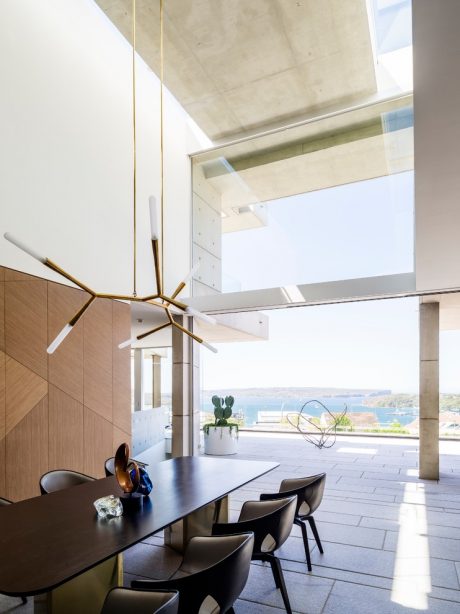 Spacious room with concrete ceiling, wooden paneling, and modern pendant lighting fixtures.