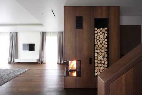 Modern living room with fireplace, wooden storage unit, and minimalist decor.