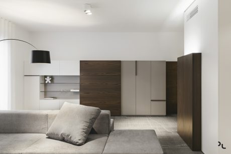 Minimalist living room with wooden cabinetry, modular seating, and recessed lighting.