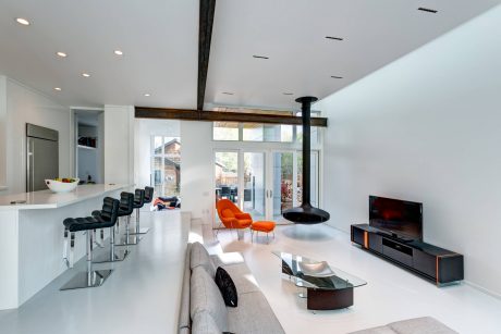 Spacious open-plan living area with modern furniture, high ceilings, and large windows.