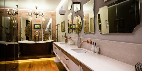 Opulent bathroom with Victorian-inspired lighting, mirrors, and decorative elements.