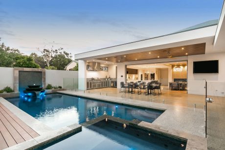 Modern, open-plan home with outdoor living area, pool, and integrated kitchen and dining space.