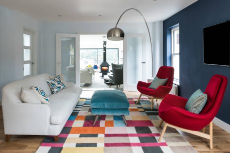 Vibrant, contemporary living room with bold color palette, modern furnishings, and architectural details.