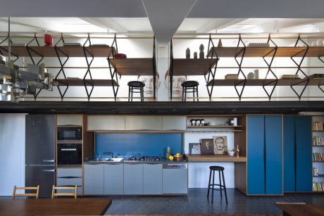 Stylish open-concept kitchen with statement shelving, modern cabinetry, and pops of blue.