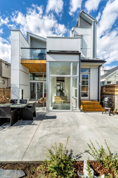 Modern multi-level home with sleek exterior, expansive glass windows, and outdoor patio.