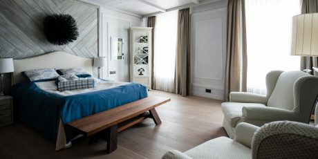 A cozy, modern bedroom with wooden accent walls, plush bedding, and stylish furnishings.