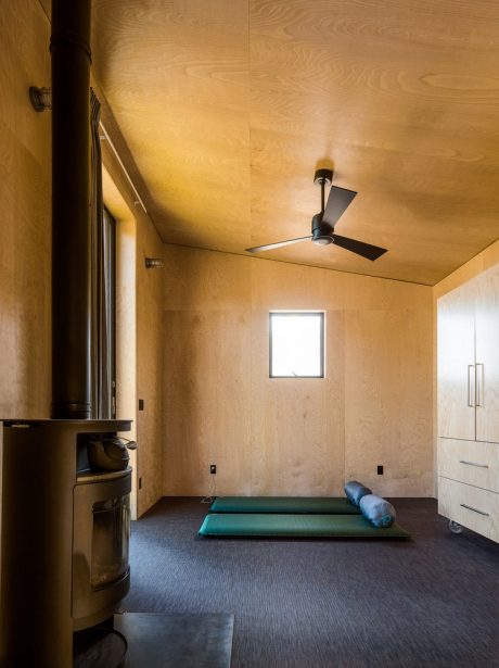 Cozy, wood-paneled room with ceiling fan and plush floor mats for relaxation.