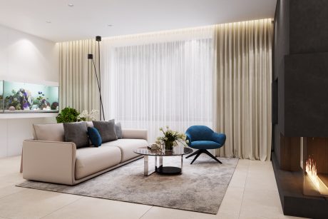 Cozy living room with neutral sofa, blue accent chair, glass-top coffee table, and large window.