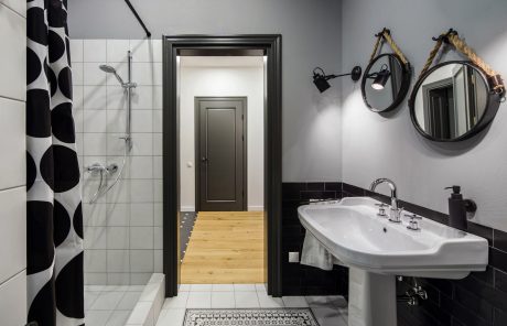 Elegant bathroom design with black and white tile pattern, modern fixtures, and rustic touches.