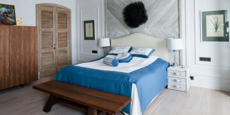 Rustic wooden furniture, geometric wall patterns, and cozy blue bedding create a tranquil space.