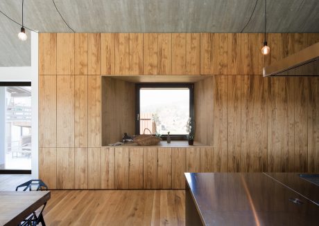 Sleek wooden paneling, minimalist shelving, and recessed lighting create a modern, cozy space.