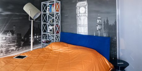 A modern bedroom with a large mural depicting Big Ben and Westminster Abbey, contrasting with sleek furnishings.