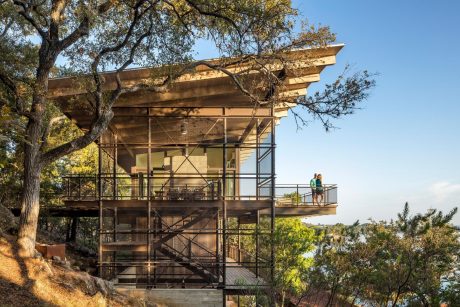Rustic wooden structure with tiered decks and architectural details amidst nature.
