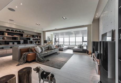 Spacious modern living room with large windows, built-in shelves, and neutral decor.
