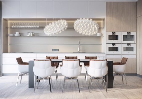 Modern, minimalist kitchen with sleek cabinetry, crystal chandeliers, and a large dining table.