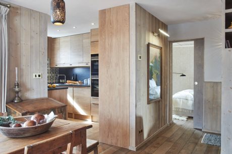 A modern rustic kitchen and dining space with warm wood accents and recessed lighting.