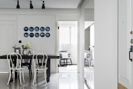 Elegant dining space with ornate plates, modern chairs, and a polished marble table.