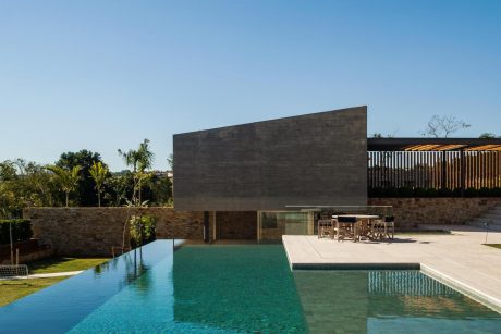 Sleek, modern architecture with a minimalist design, featuring an inviting pool and lush greenery.