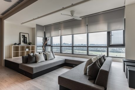 Spacious living room with large windows, modern furniture, and minimalist decor.