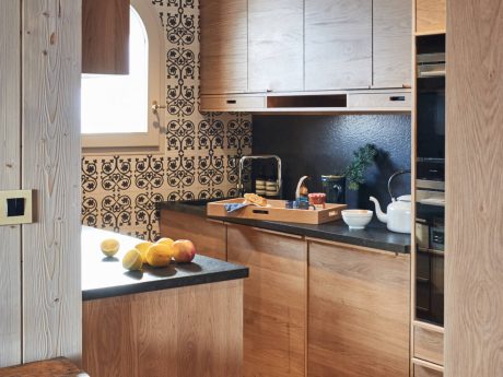 Rustic kitchen design with patterned tile backsplash and wooden cabinetry.