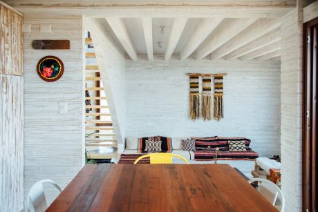 Rustic interior with wooden beams, patterned textiles, and a wooden dining table.