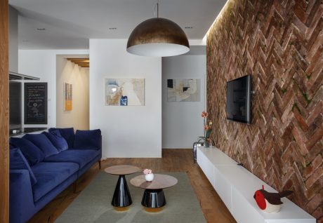 A cozy living room with an exposed brick wall, sleek furniture, and abstract artwork.