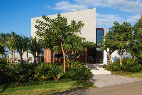 Tropical exterior with minimalist concrete building, trees, and lush landscaping.
