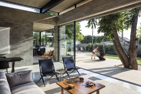 Sleek, modern interior with glass walls, concrete accents, and lush outdoor views.