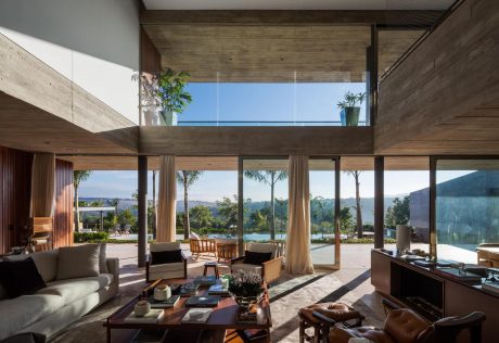 Expansive open-plan living area with panoramic views, wood-clad ceilings, and elegant furnishings.