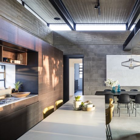 Stunning industrial-style interior with concrete walls, sleek cabinets, and stylish lighting.
