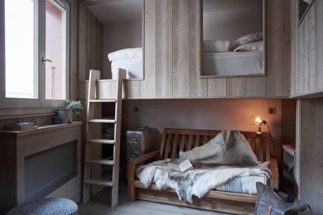 Rustic wood paneling, cozy bunk bed, reading nook with lamp, minimalist decor.