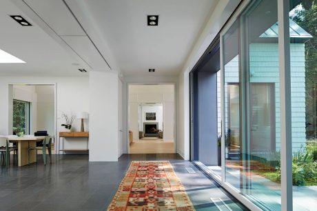 Expansive modern interior with sleek design, large windows, and a decorative rug.