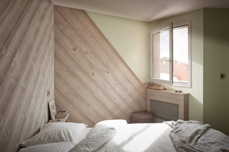 A cozy bedroom with a wooden accent wall, adding warmth and texture to the space.